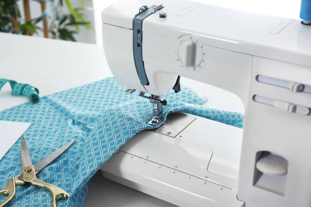Швейная машина с тканями на столе, крупным планом
 - Фото, изображение