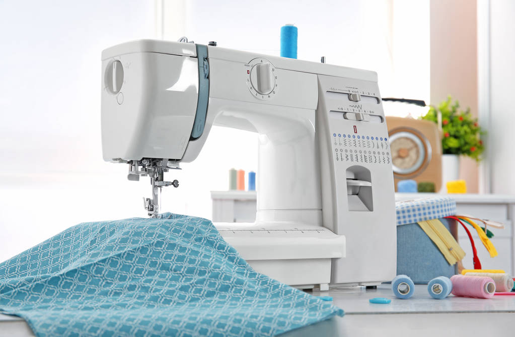 Швейная машина, ткань и нити на столе
 - Фото, изображение