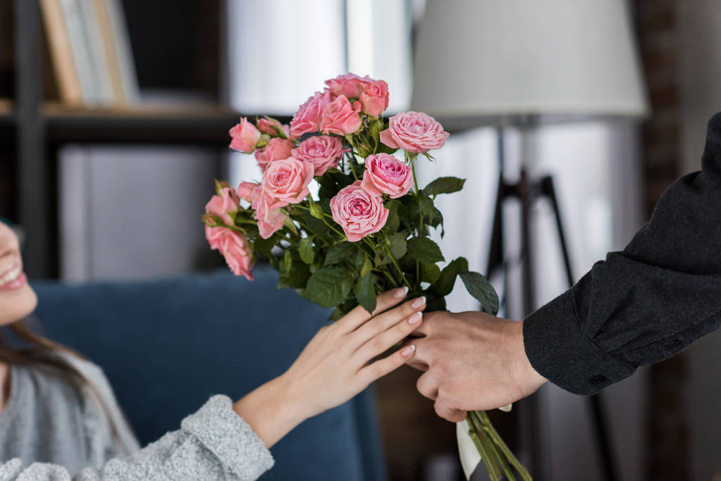 imagen recortada de novio presentando ramo de rosas a la novia en el día internacional de la mujer
 - Foto, imagen