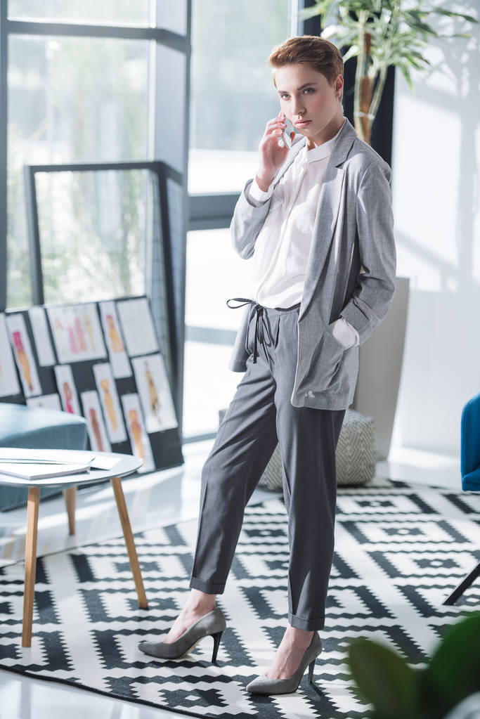 привабливий молодий дизайнер моди розмовляє по телефону в офісі
 - Фото, зображення
