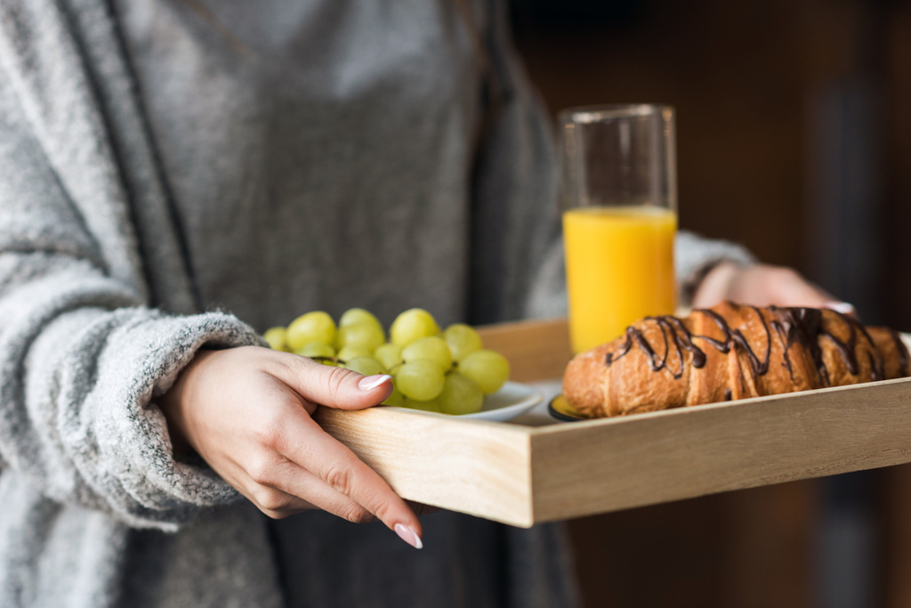 bijgesneden afbeelding van meisje houden dienblad met ontbijt  - Foto, afbeelding