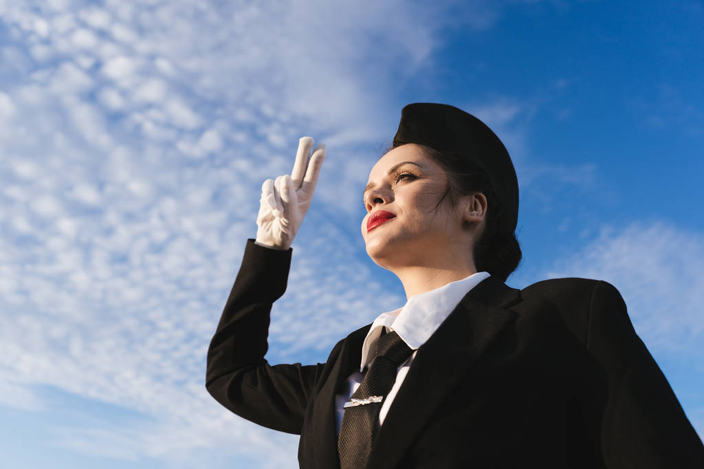 letuška žena v uniformě na obloze na pozadí - Fotografie, Obrázek