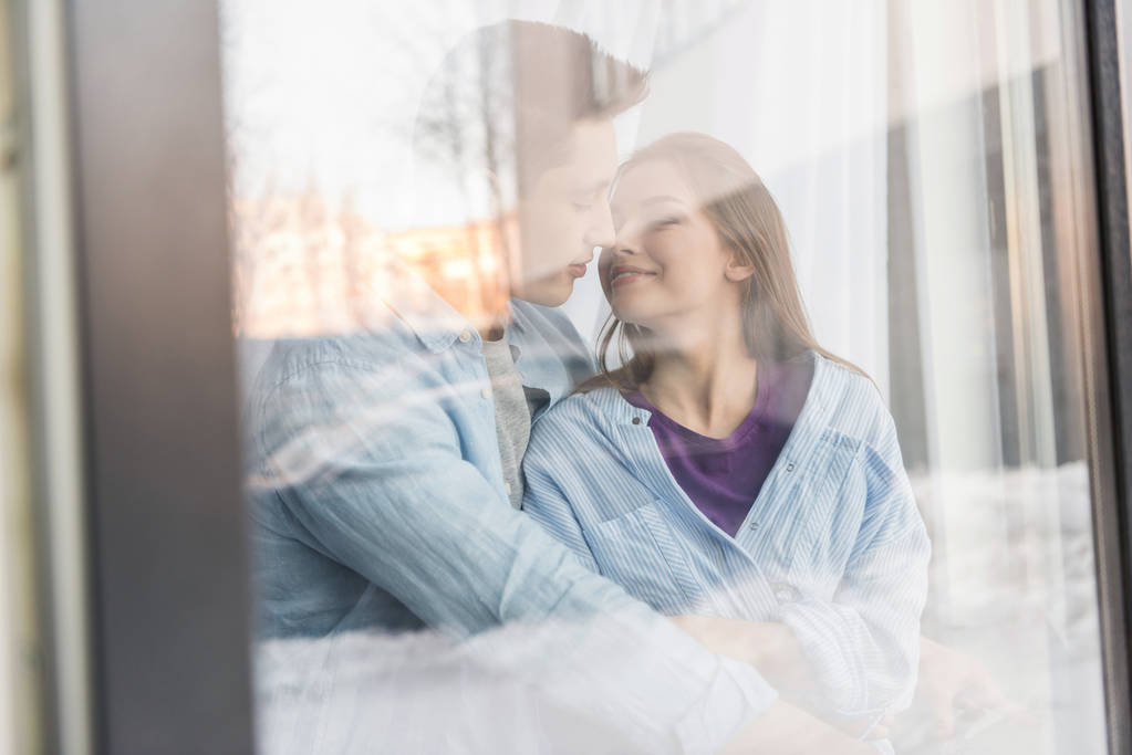 view through window on couple going to kiss with closed eyes - Photo, Image