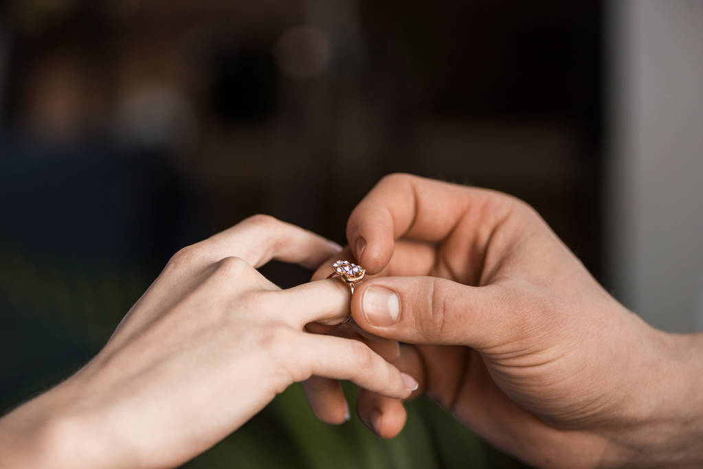 cropped image of boyfriend proposing girlfriend and wearing engagement ring - Photo, Image