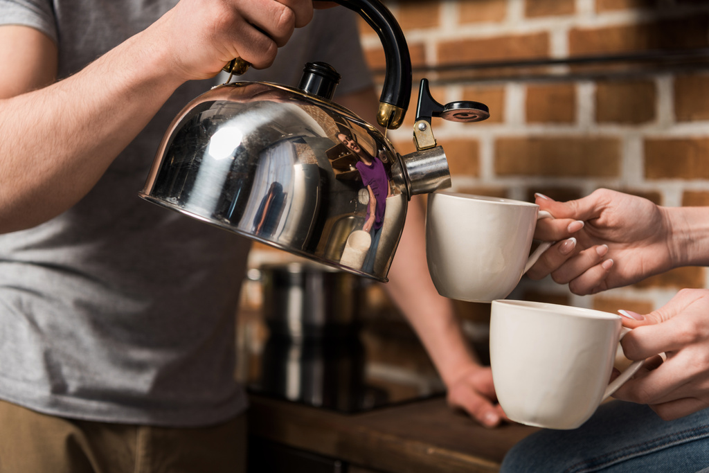 imagen recortada de novio vertiendo café en tazas
 - Foto, imagen