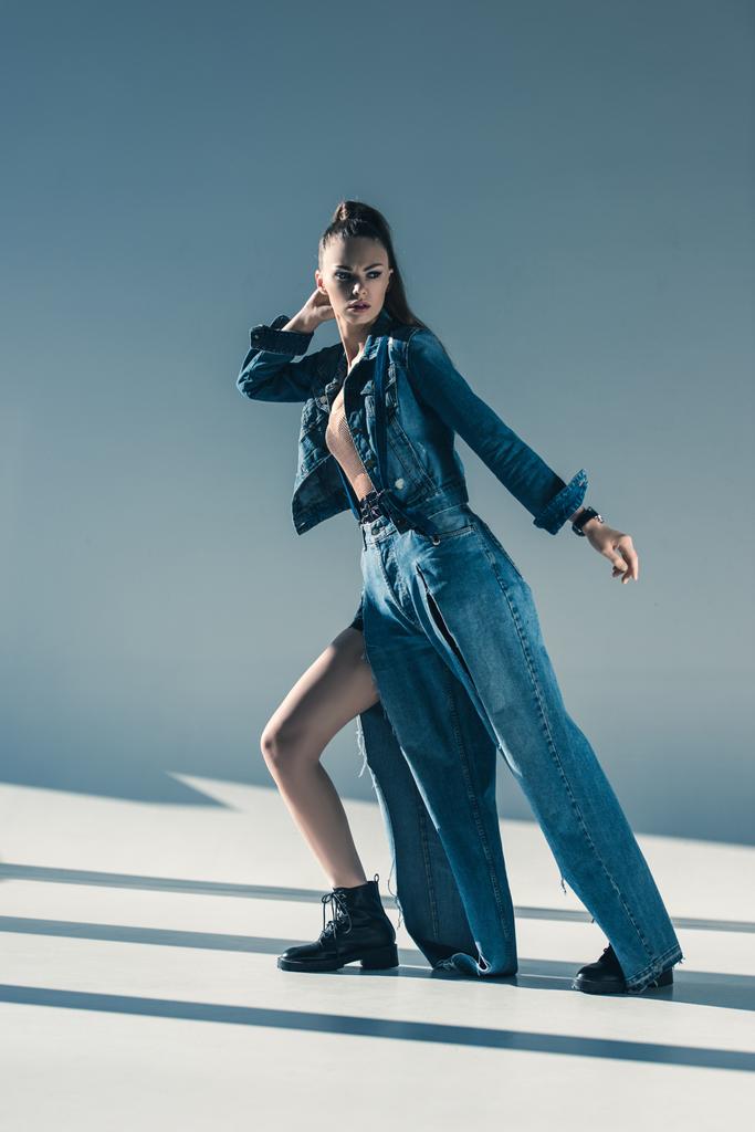 красивая молодая женщина в модной джинсовой одежде позирует для модной съемки
 - Фото, изображение