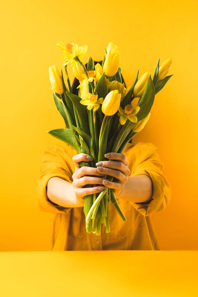 крупный план девушки с красивыми желтыми весенними цветами на желтом
 - Фото, изображение