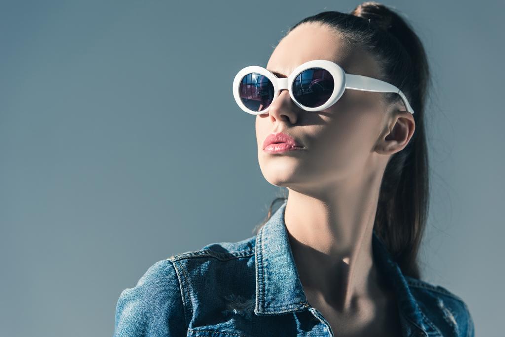 beautiful stylish woman in denim clothes and sunglasses, isolated on grey - Photo, Image