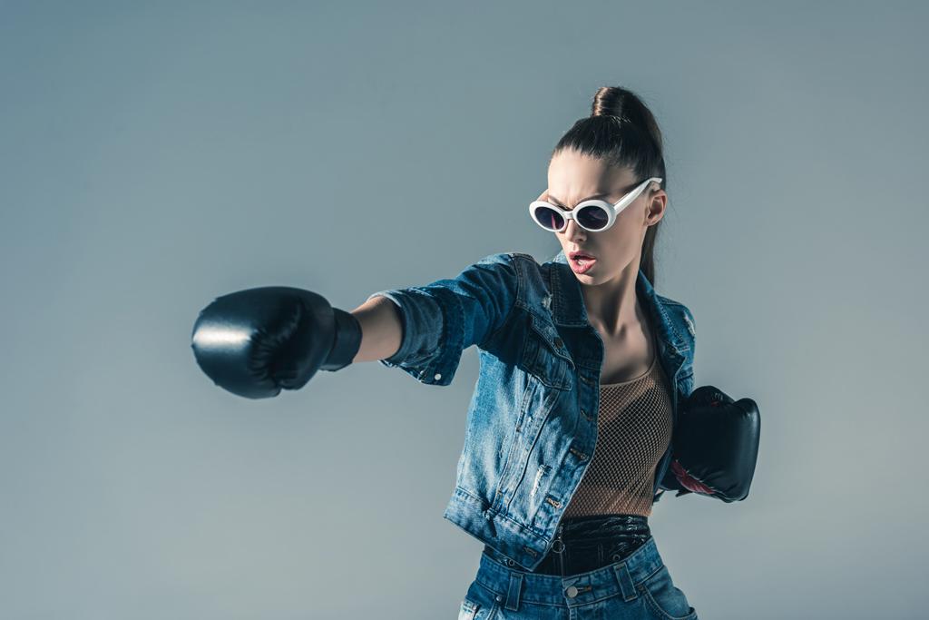 menina boxe elegante em roupas jeans e óculos de sol, isolado em cinza
 - Foto, Imagem