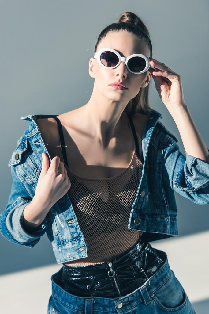 stylish model posing in denim clothes and sunglasses - Photo, Image
