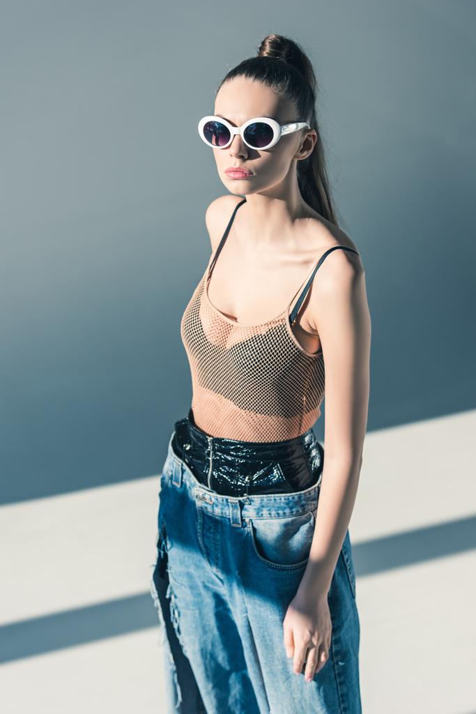 fashionable sexy model posing in jeans and sunglasses - Photo, Image