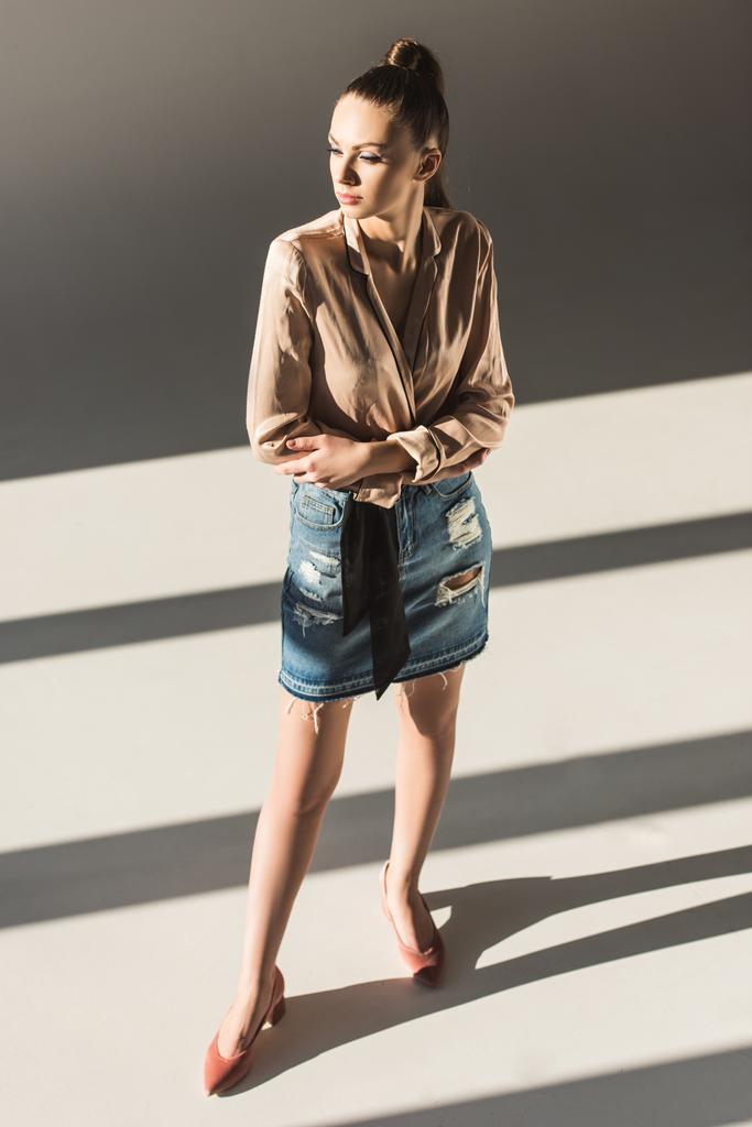 модна дівчина позує в блузці і джинсовій спідниці
 - Фото, зображення
