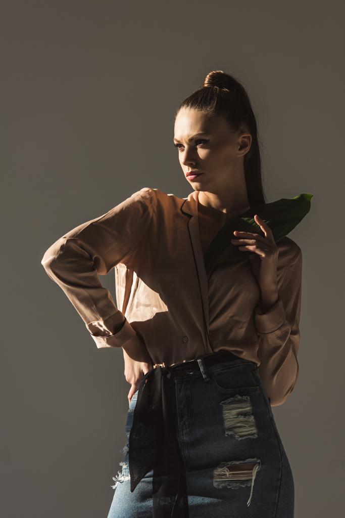 kot etek ve bluz gri izole yaprak, holding moda kadın - Fotoğraf, Görsel