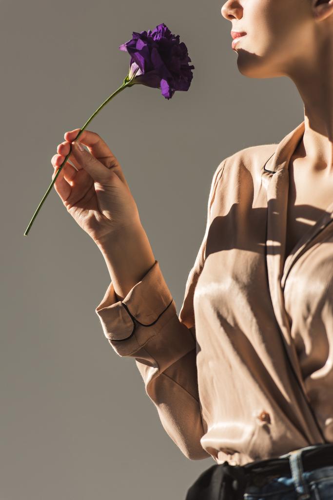 vue recadrée d'une femme tenant une fleur violette, isolée sur gris
 - Photo, image