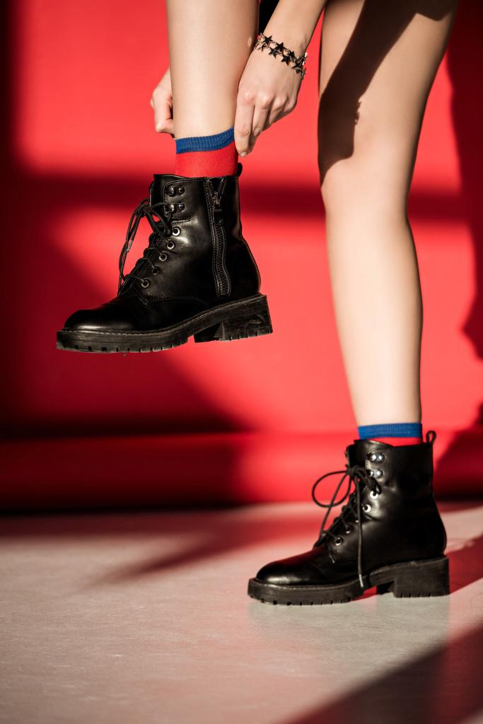seção baixa de menina posando em sapatos pretos no vermelho
  - Foto, Imagem