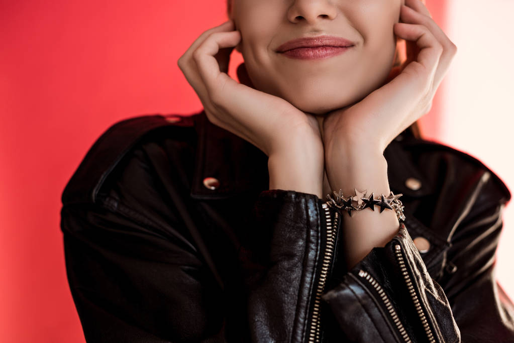 cropped view of girl in black leather jacket on red - Photo, Image