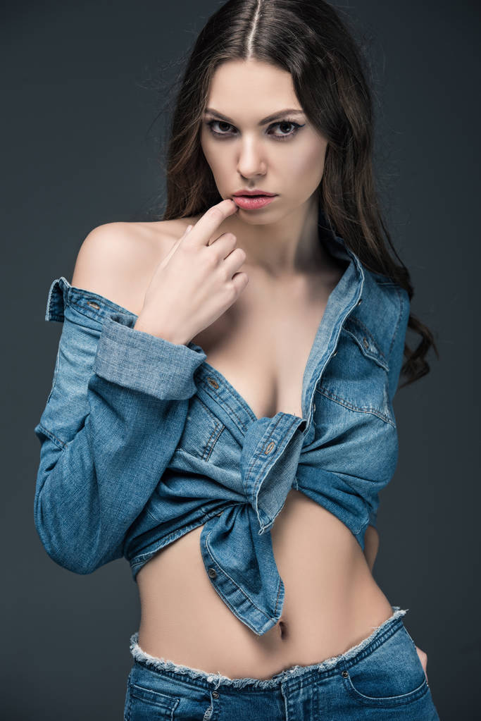 attraente ragazza appassionata posa in camicia di jeans, isolato su grigio
 - Foto, immagini