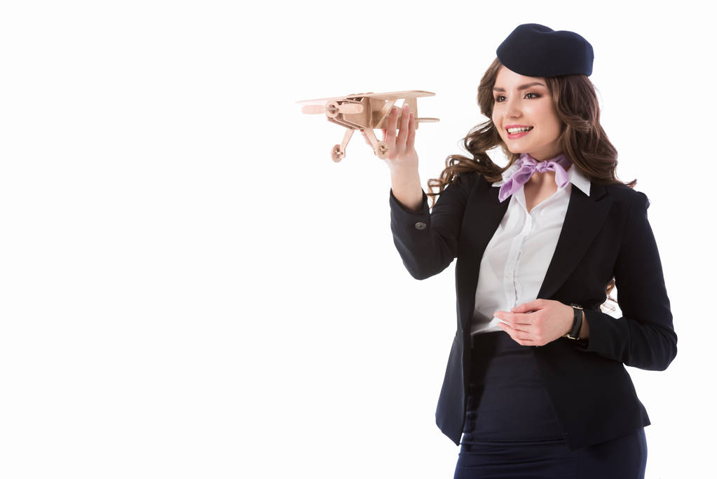 mooie stewardess spelen met vliegtuig model geïsoleerd op wit - Foto, afbeelding