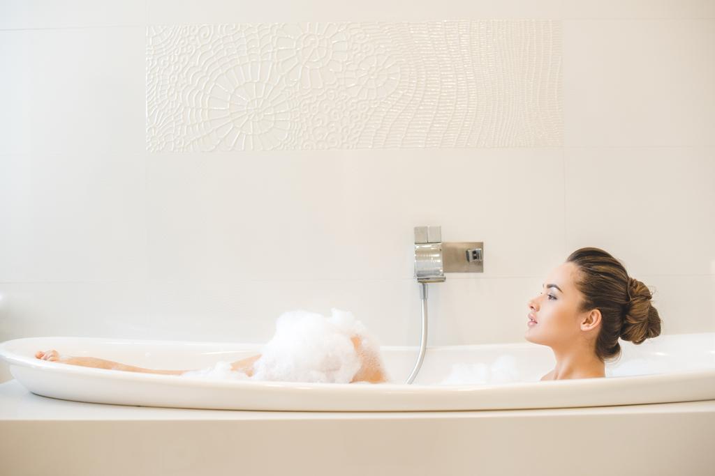 side view of young beautiful woman taking bath at home - Photo, Image