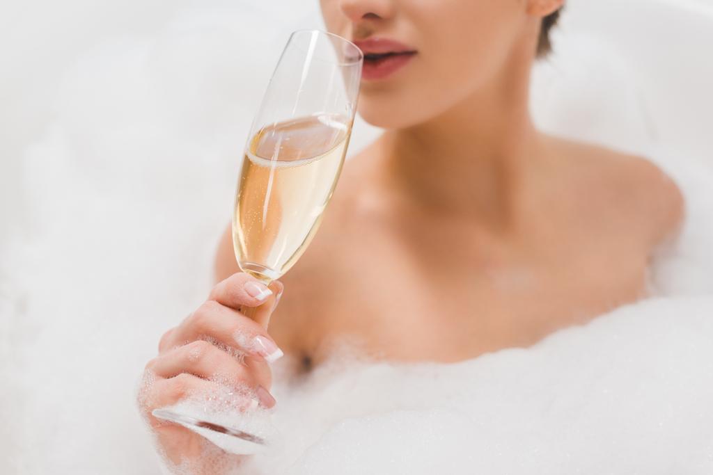 частковий вид на красиву жінку зі склянкою шампанського приймаючи ванну
 - Фото, зображення