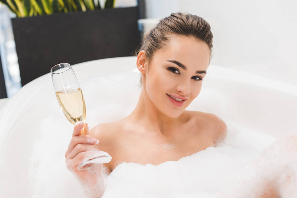 hermosa mujer con copa de champán tomando baño
 - Foto, Imagen
