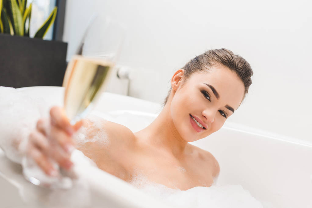 επιλεκτική εστίαση του όμορφη γυναίκα με ποτήρι σαμπάνια κάνει μπάνιο - Φωτογραφία, εικόνα