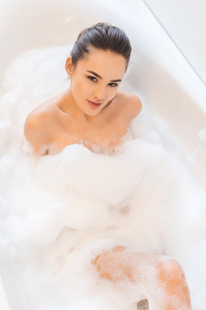 felülnézete a gyönyörű fiatal nő, figyelembe véve a fürdő otthon - Fotó, kép