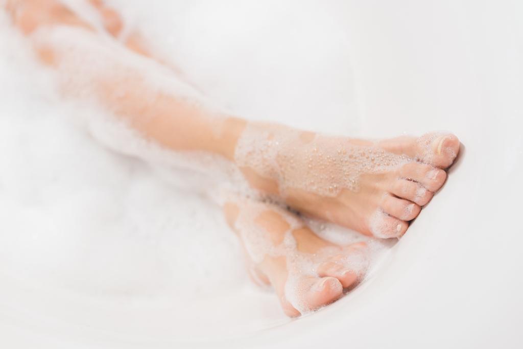 częściowy widok kobiece nogi w kąpieli z pianką - Zdjęcie, obraz