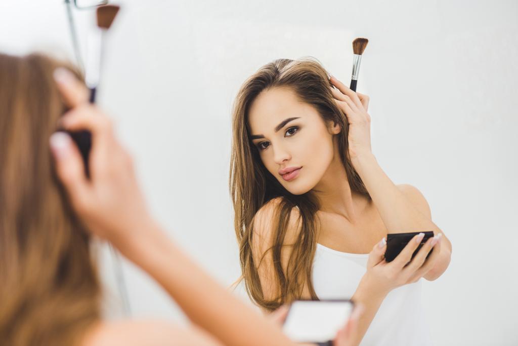 καθρέφτη αντανάκλαση της όμορφης νεαρής γυναίκας εφαρμογή μακιγιάζ - Φωτογραφία, εικόνα