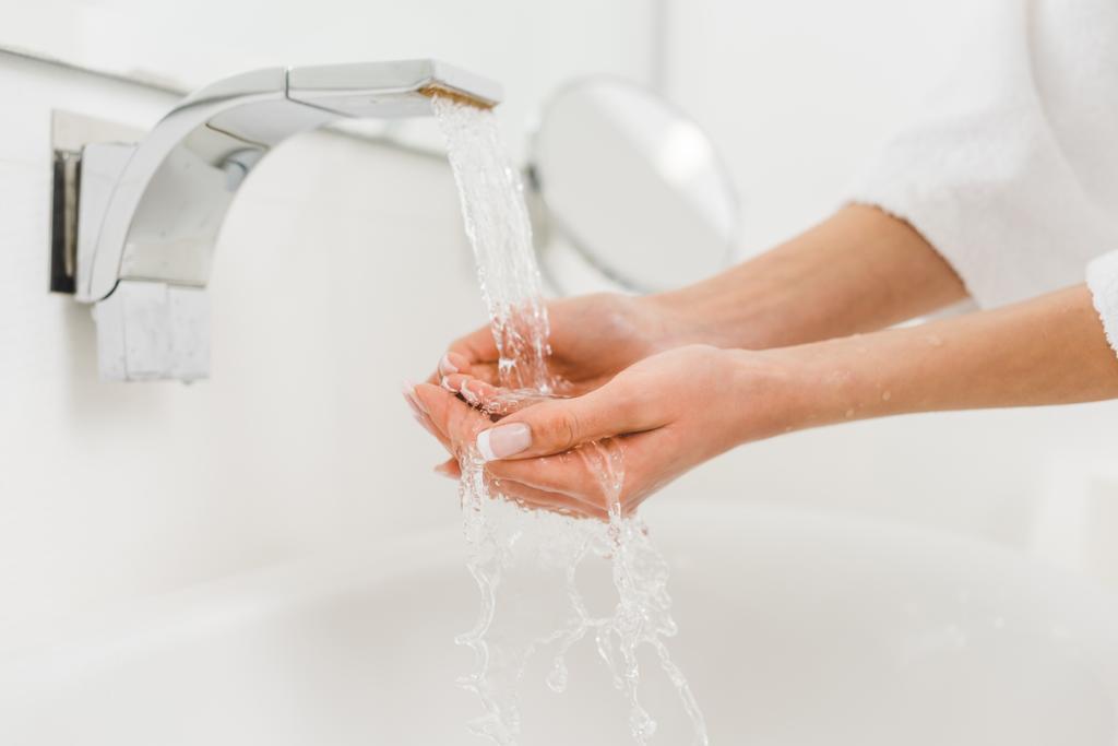 частковий вигляд жінки, що миє руки вдома
 - Фото, зображення