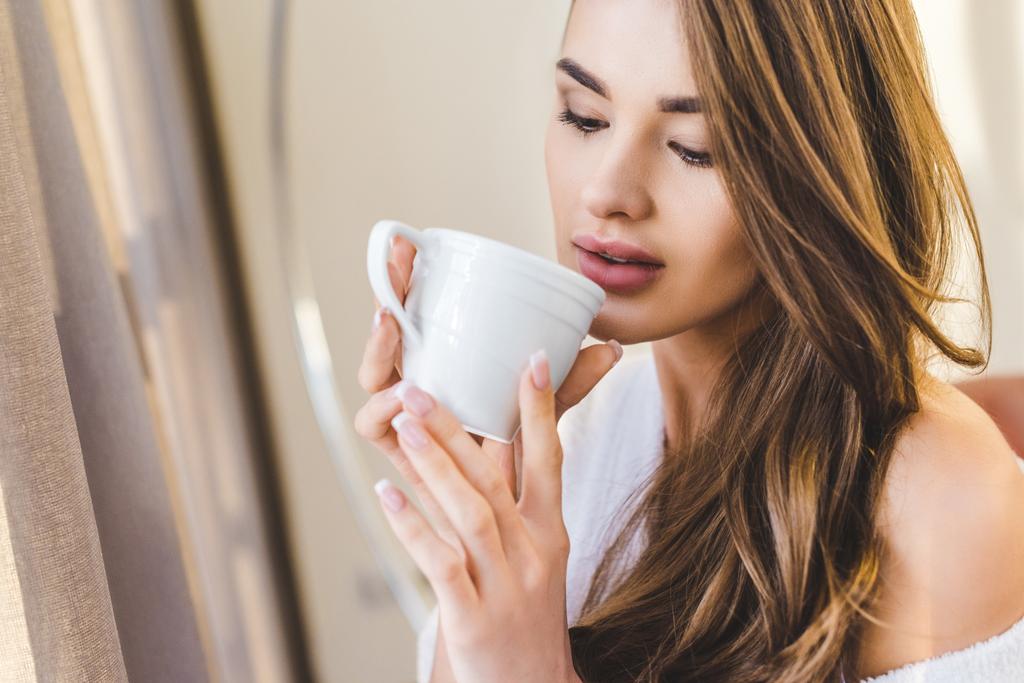 ritratto di bella giovane donna in accappatoio con tazza di caffè a casa
 - Foto, immagini