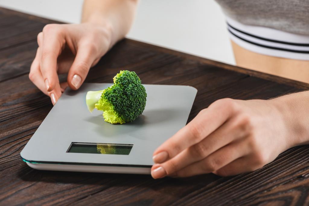 cropped shot of woman measuring weight of broccoli - Photo, Image