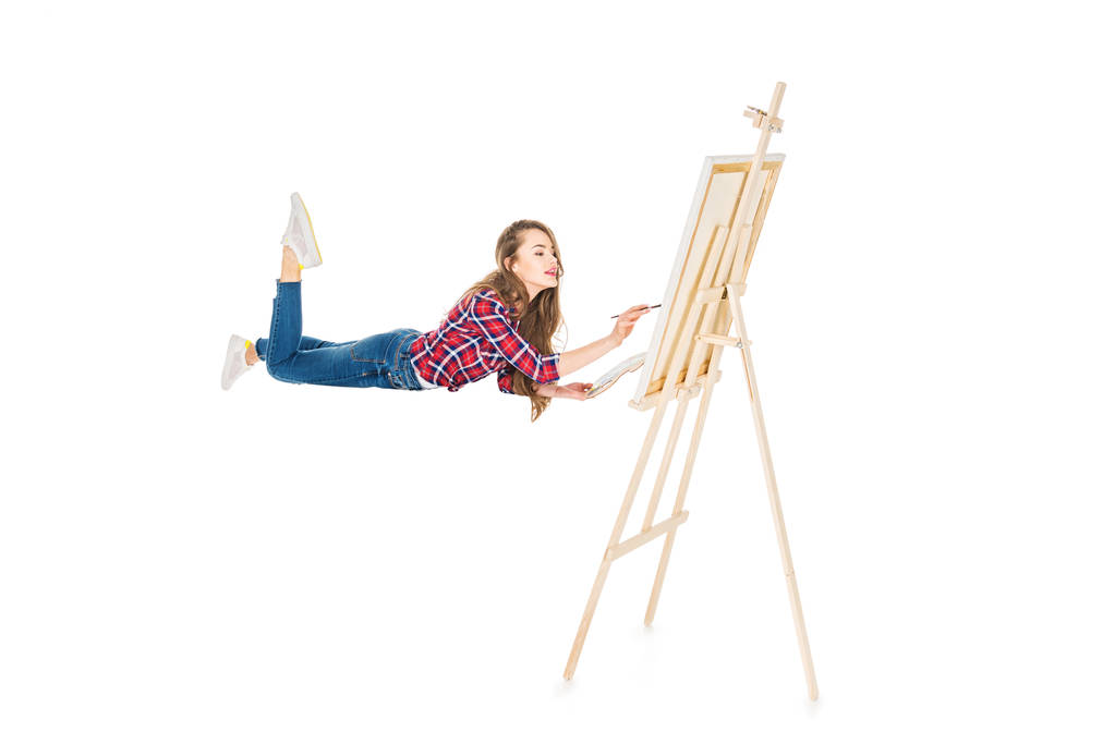 levitating ve üzerinde beyaz izole şövale üzerinde boyama kız - Fotoğraf, Görsel