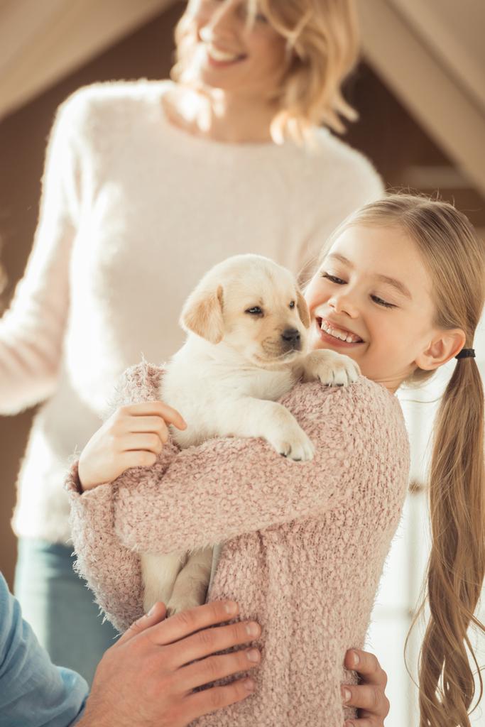 madre y feliz hijita jugando con adorable cachorro labrador
 - Foto, Imagen