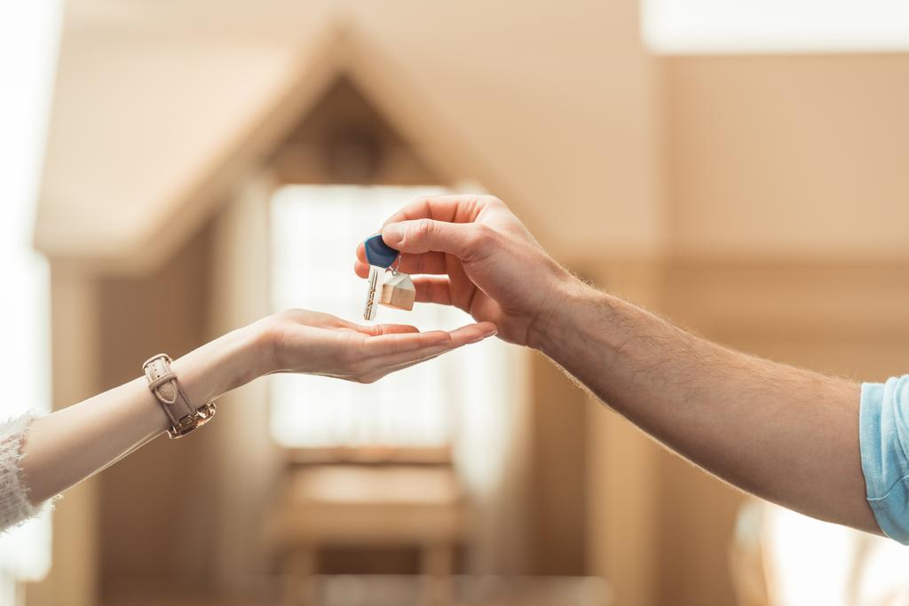 обрезанный снимок агента по недвижимости, передающего ключ клиенту
 - Фото, изображение