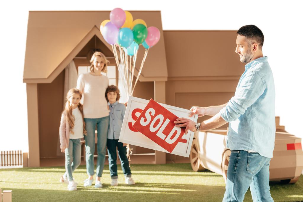 щаслива молода сім'я переїжджає в новий картонний будинок ізольовано на білому
 - Фото, зображення