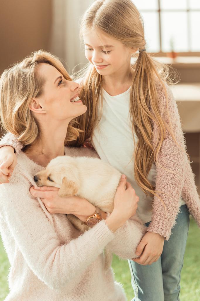 matka a šťastná dcera hraje s rozkošný labrador štěně - Fotografie, Obrázek