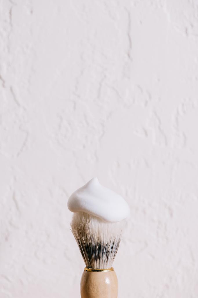 tıraş fırçası ile köpük beyaz duvara görünümünü kapat - Fotoğraf, Görsel