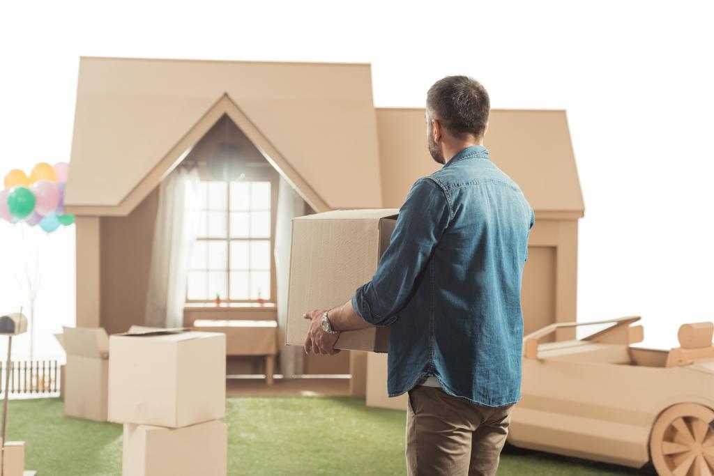 hombre con cajas moviéndose en nueva casa de cartón aislado en blanco
 - Foto, Imagen