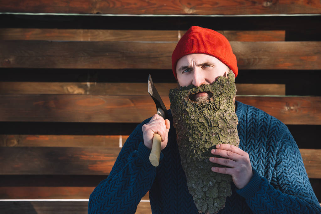 portret człowieka z brodą, wykonane z drewna kory i toporem w ręku na zewnątrz - Zdjęcie, obraz