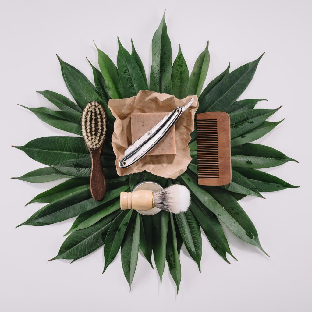 vue de dessus des outils de barbier disposés pour le rasage sur feuilles vertes isolées sur gris
 - Photo, image