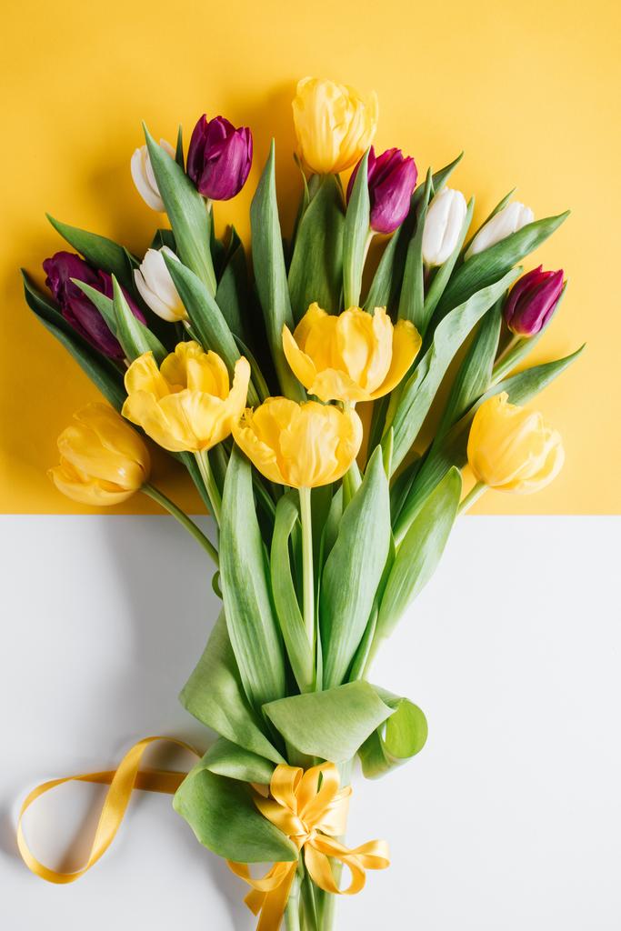 pohled shora na žluté, růžové a bílé tulipány s mašlí na den mezinárodní Dámské - Fotografie, Obrázek
