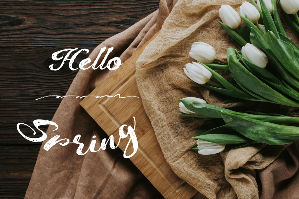 vista dall'alto dei tulipani primaverili su tovaglia e tavola di legno con scritte Hello Spring
 - Foto, immagini