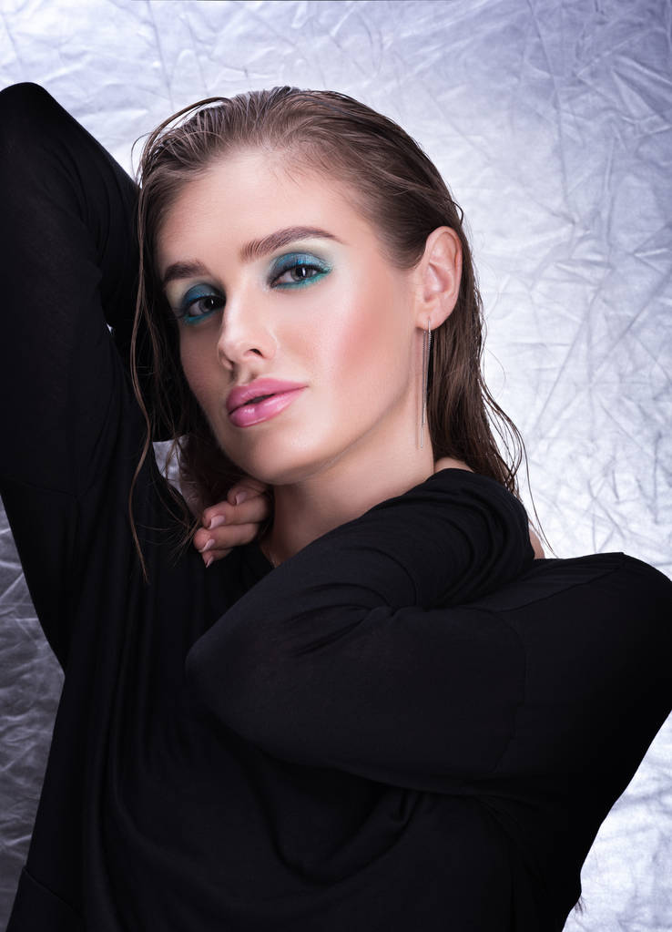 Retrato vertical de una joven sexy en negro. Maquillaje profesional y cabello húmedo
 - Foto, imagen