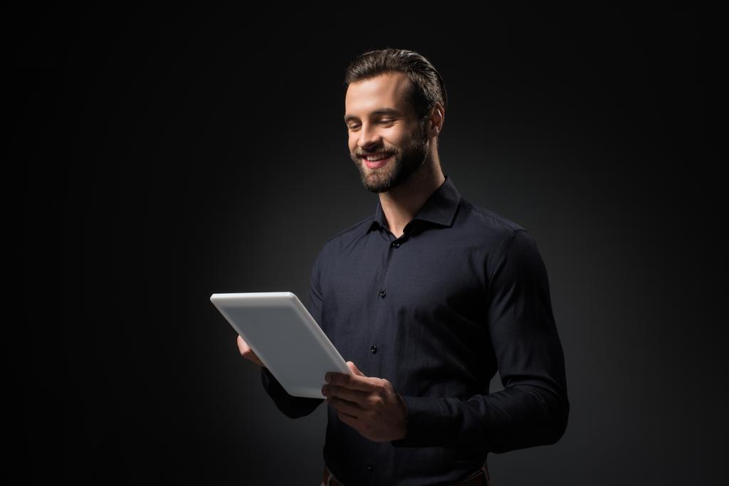 портрет улыбающегося мужчины с цифровой табличкой, изолированной на черном
 - Фото, изображение