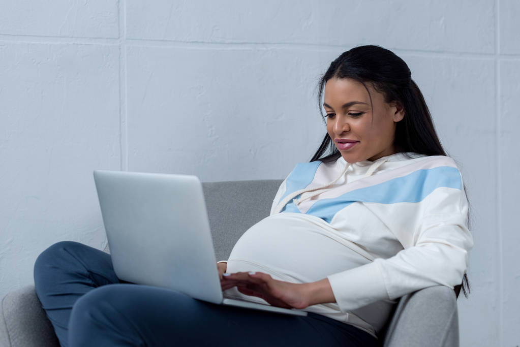 hermosa africana americana embarazada mujer usando laptop
 - Foto, Imagen