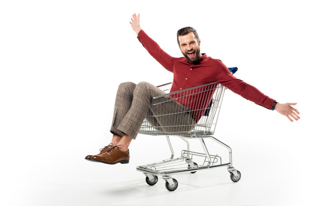 cheerful man sitting in shopping cart isolated on white - Photo, Image