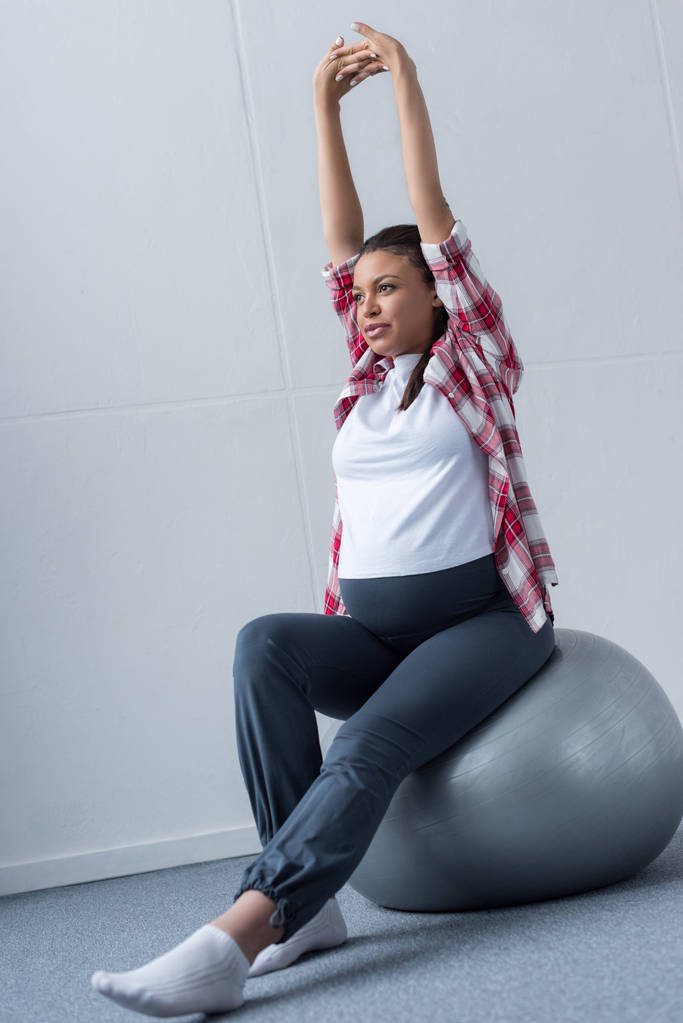 sportive african american pregnant woman stretching on fit ball - Photo, Image