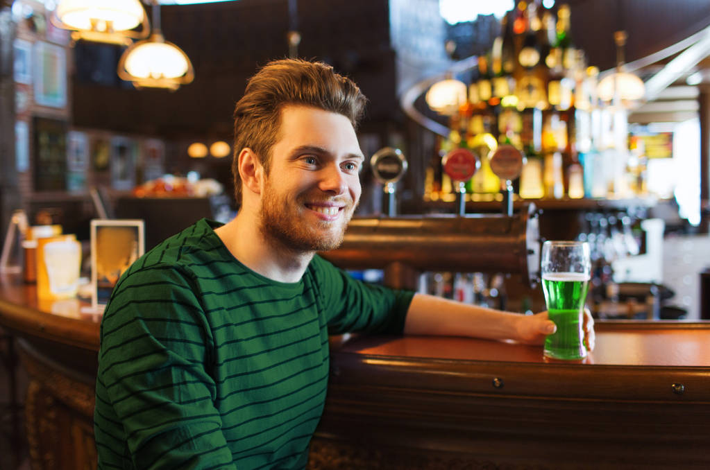 man drinking green beer at bar or pub - Photo, Image