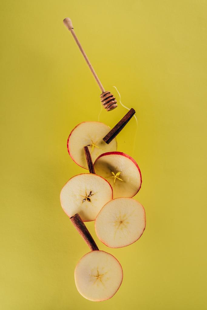 close up view of levitating pieces of apple, cinnamon sticks and honey - Photo, Image